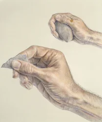 Handen die een primitief gereedschap en een steen vasthouden